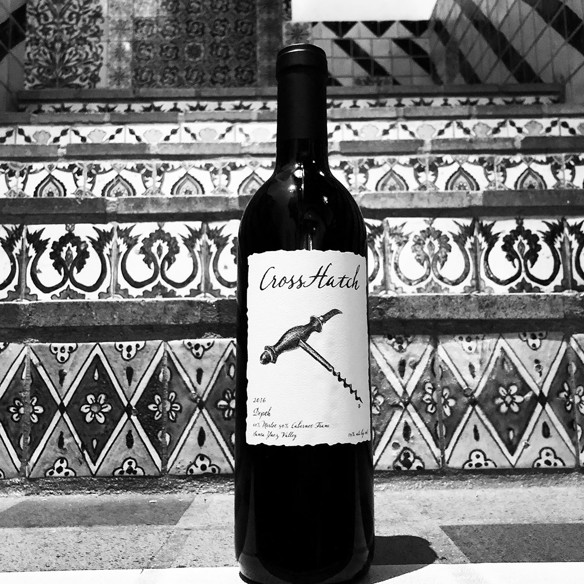 A bottle of CrossHatch Wines "Depth" in front of old world tiled steps (black and white)